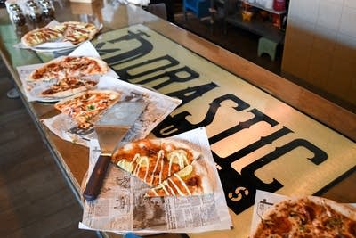 Slices of pizza sit on a bar for an event at Drastic Brewing.