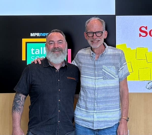 Two men stand together for a portrait