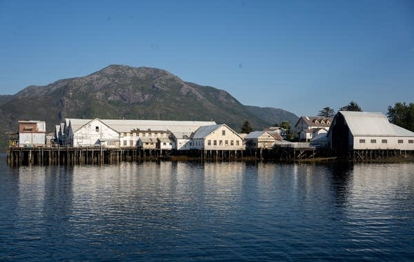 A gray building is seen across the water.