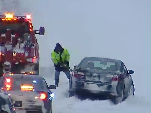 A tow truck operator works to remove a car that went off the road