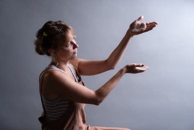 A woman gestures in an upwards motion