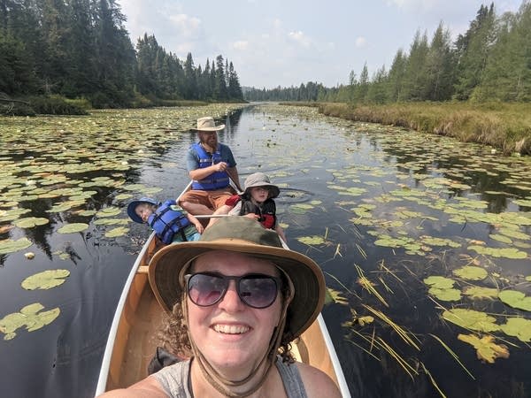 A family with two young children canoes