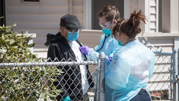 Emergency medical workers check a patient who was in isolation experiencing worsening COVID-19 symptoms in Chelsea, Massachusetts.
