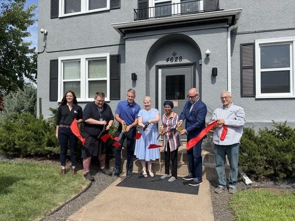 Seven people cut a ribbon