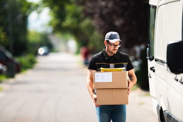 A postman delivers a package to a customer (Photo: Getty)