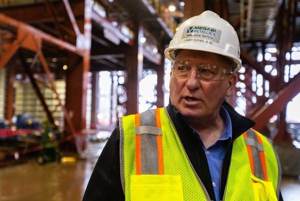 a man in a hard hat and yellow vest in a building