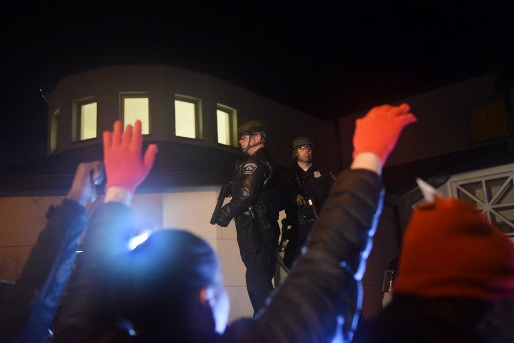 Protesters chant and yell at police.