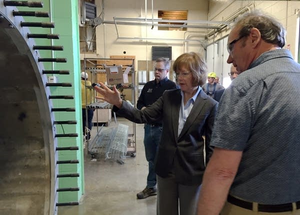 Lt. Gov. Tina Smith looks at a wind turbine base with Steve Vietor.