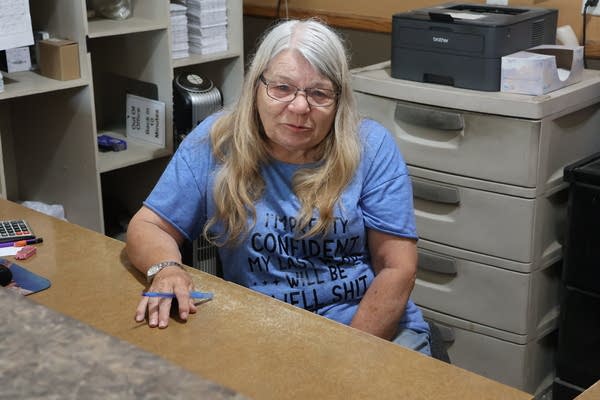 A woman in blue shirt behind a desk
