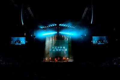 Six musicians performing onstage in a large arena