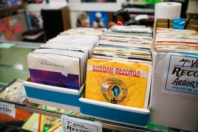 Crates of 45rpm singles atop a display case in a record store