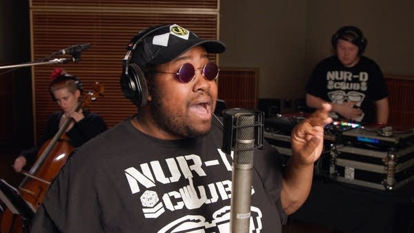 Man with sunglasses performing a studio session with orchestra members-04