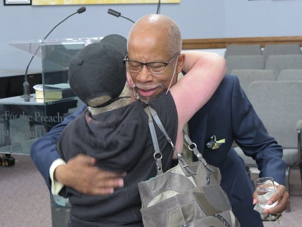 Pastor William Land is greeted by a worshipper