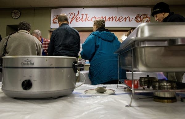 Patrons walk past crock pots and heaters during the First Lutheran dinner.