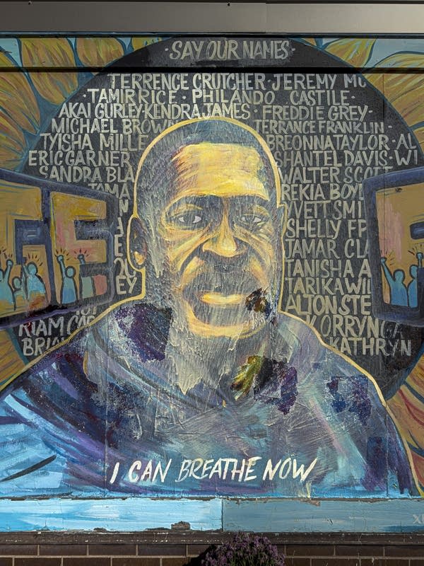 A mural of George Floyd, the center covered in off-white paint.