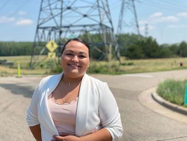 A person stands in front of power lines 