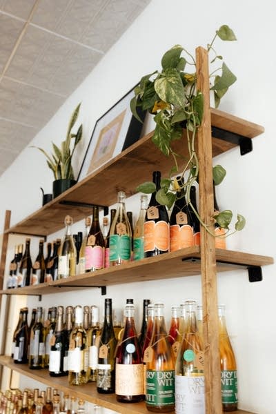 A wooden shelf holds bottles of non-alcoholic beverages.