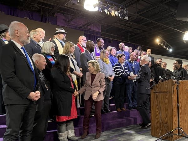 A group of people talk and pose for a photo