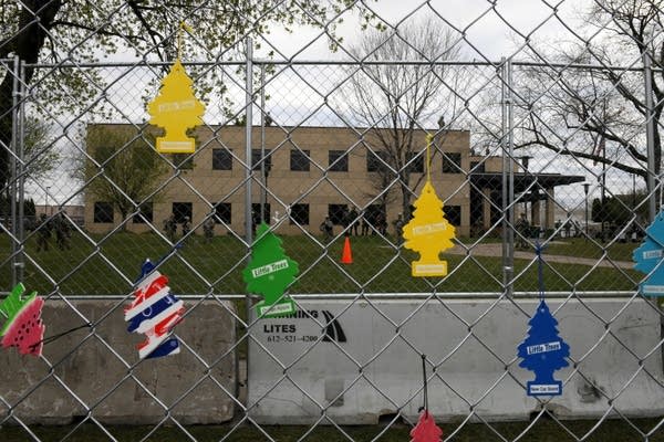 Air fresheners hang from a fence.