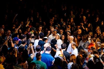 A band form a circle to play music in the middle of an audience 