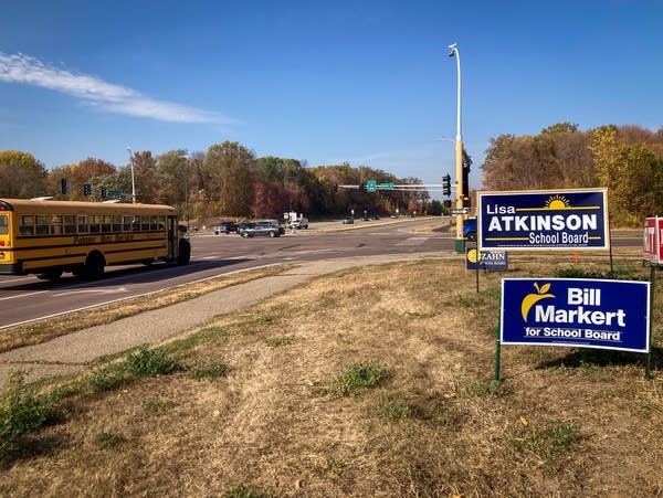 Political signs dot the grassy corner of an intersection