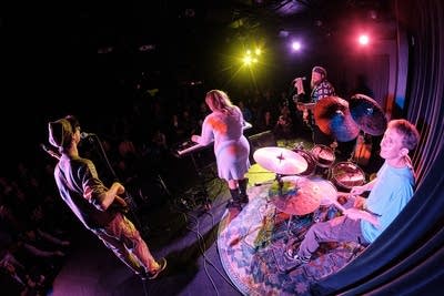 Four musicians performing onstage