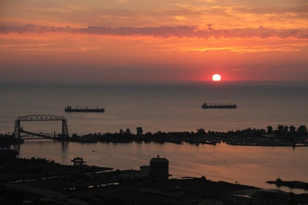 Two ships at anchor at sunrise