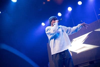 A rapper performs onstage during a show in a music venue