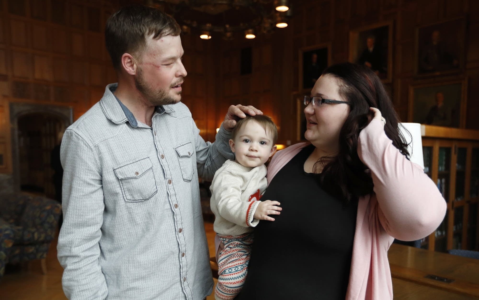 Lilly Ross holds her 17-month-old son as she talks with Andy Sandness.