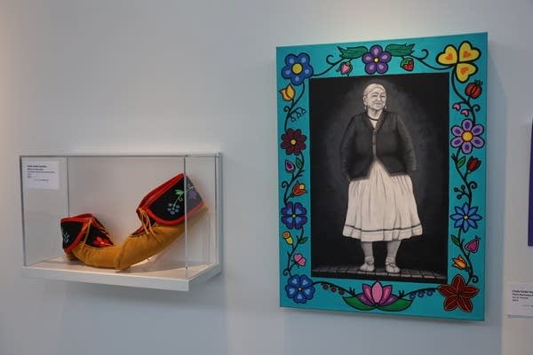 A museum display of embroidered shoes (left) and an acrylic portrait of the artist's grandmother (right).