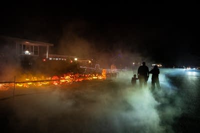 a family walks through fog to see halloween displays