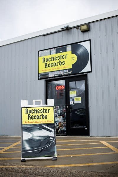 Exterior of a record store with a matching sandwich board just outside the entrance 