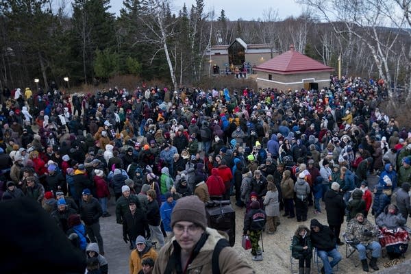 A large crowd of people in winter gear gathers for an event.