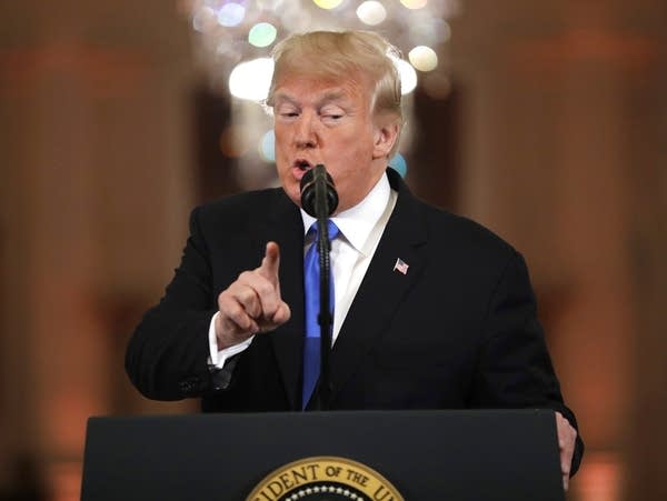 President Donald Trump points during a news conference.