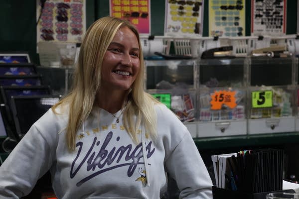 A woman in a gray hoodie poses for a photo.