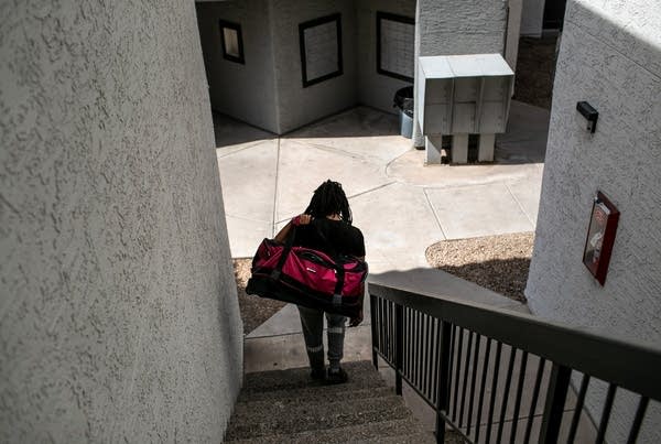 An apartment resident carries out a bag of clothing while being evicted for non-payment of rent on October 5, 2020 in Phoenix, Arizona.