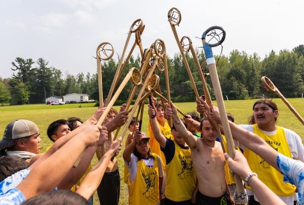 stickball players raising their sticks