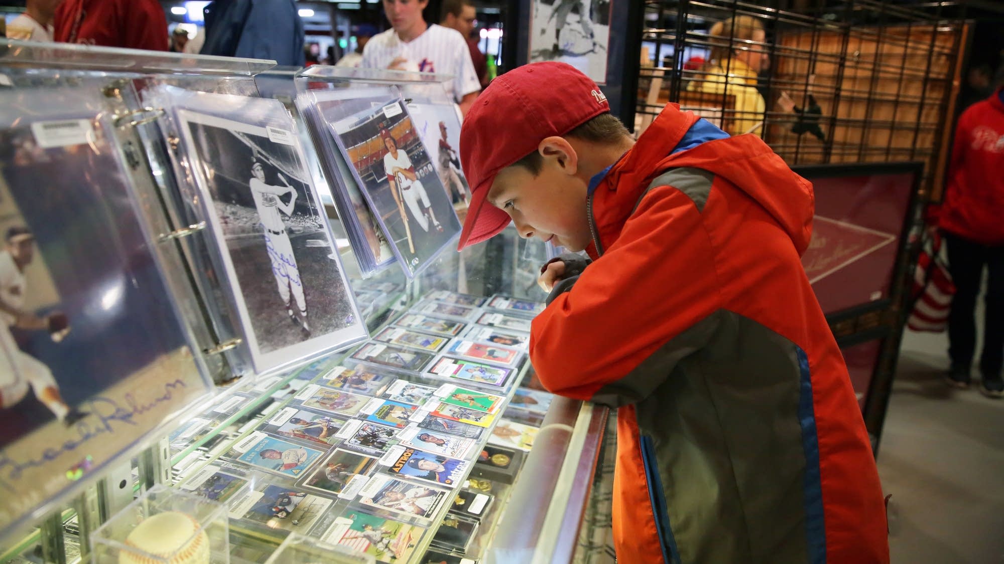 A close-up of a collector's hands holding a freshly opened pack of baseball cards, with a look of anticipation on their face.