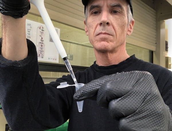 A man fills a test tube with a sample of water.