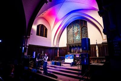 A musician sings and plays guitar onstage