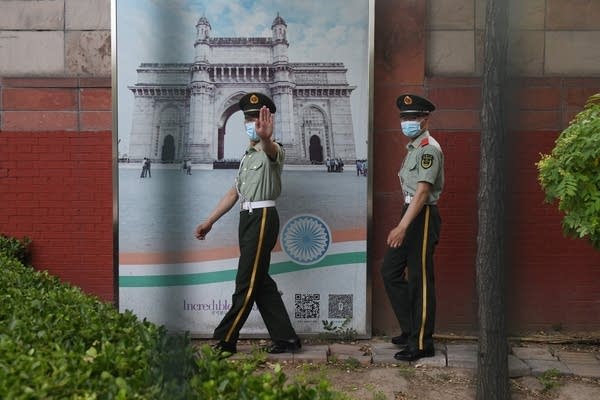 Two Chinese paramilitary police officers patrol outside the Indian embassy in Beijing, China.