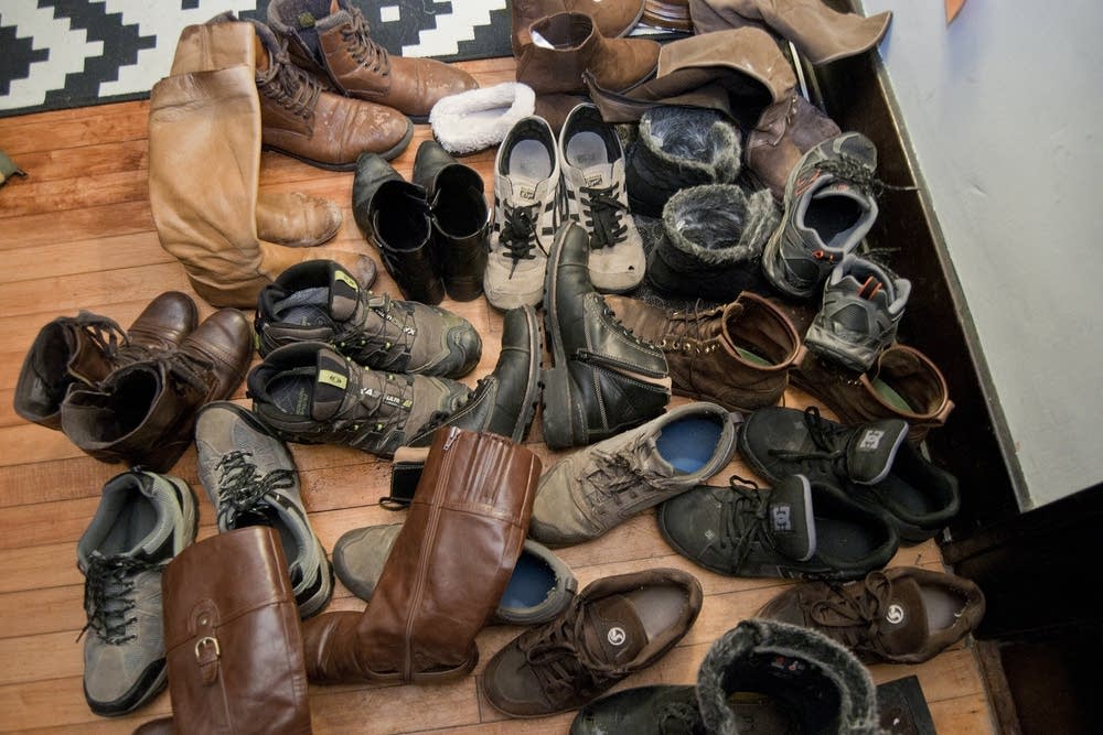 A pile of shoes in the entryway of a home concert.