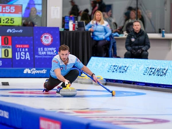 A curler makes a throw during a competition
