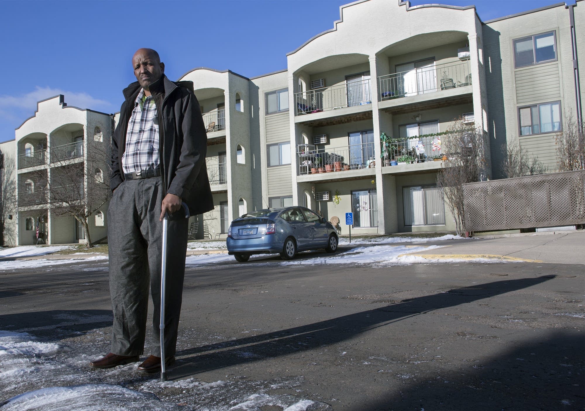 Mahamed Iye stands in front of the apartment complex where he lives.