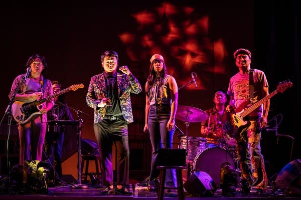 People stand on a stage with instruments