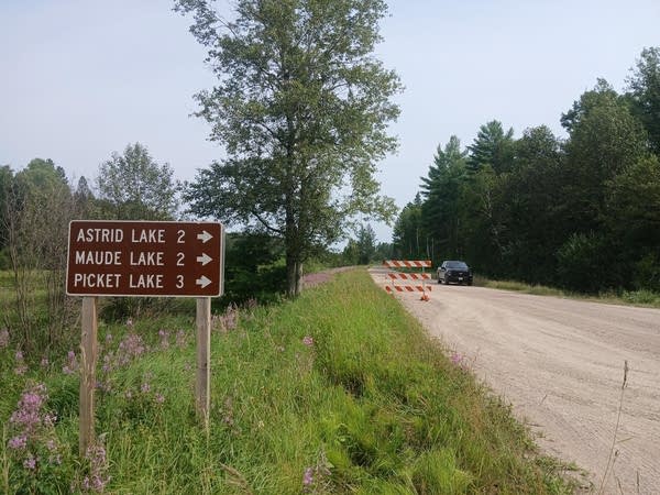 a dirt road with a barrier blocking access