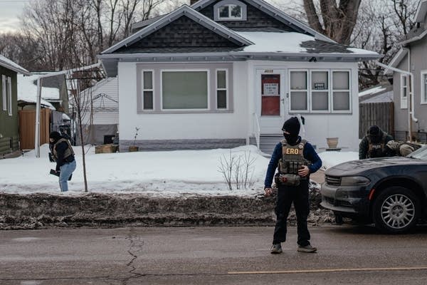 Federal agents outside a house
