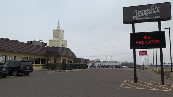 An empty parking lot with a sign that says "We are open."