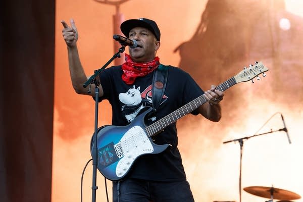 A man sings and plays guitar onstage