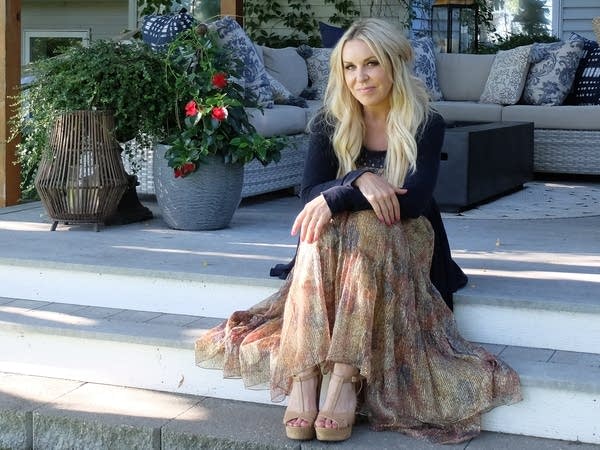 a woman sits outdoors on steps